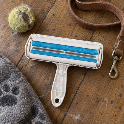 Reusable pet hair roller with two blue fabric brushes on timber floorboards