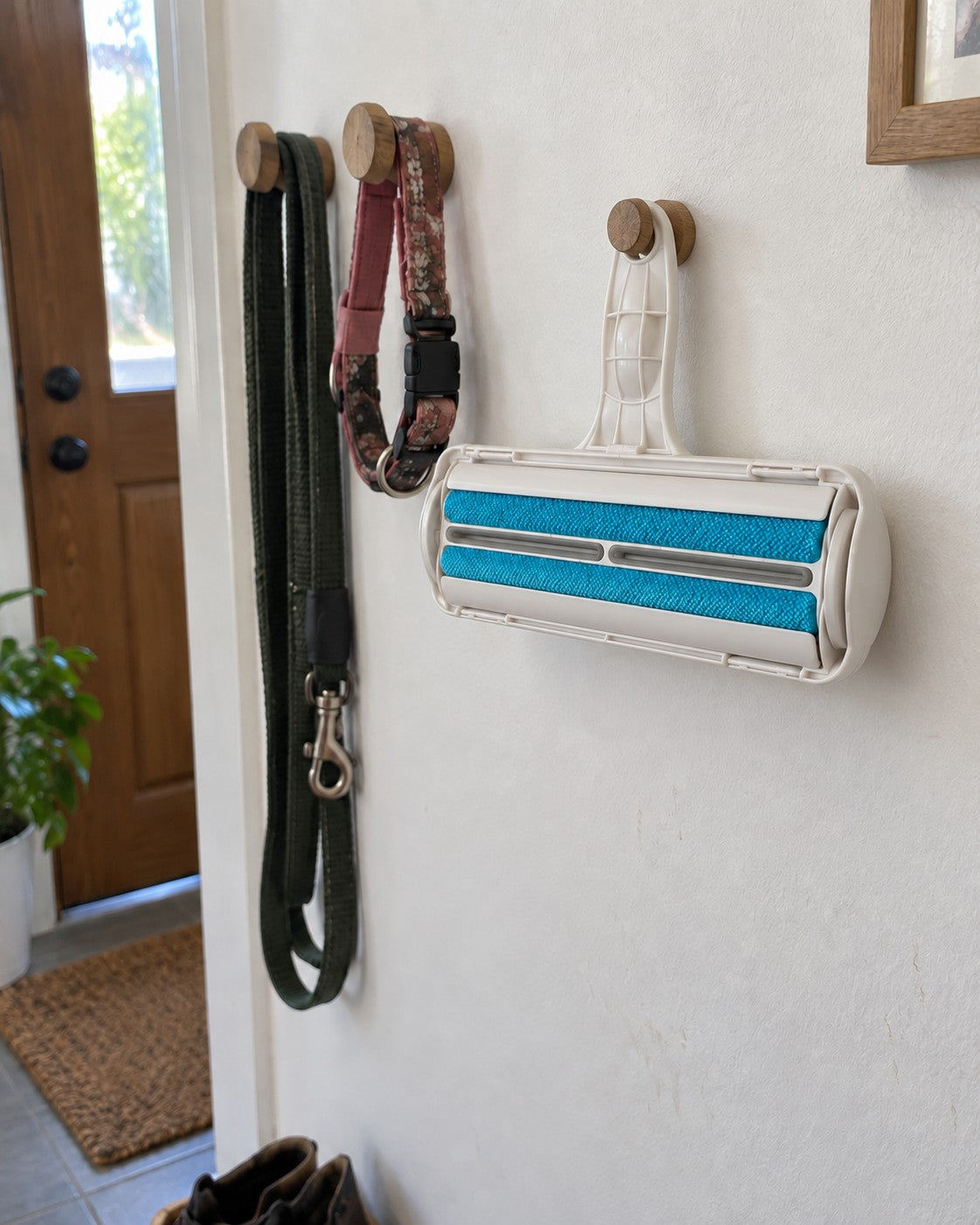 Pet hair roller hanging on a hook next to a dog lead and collar
